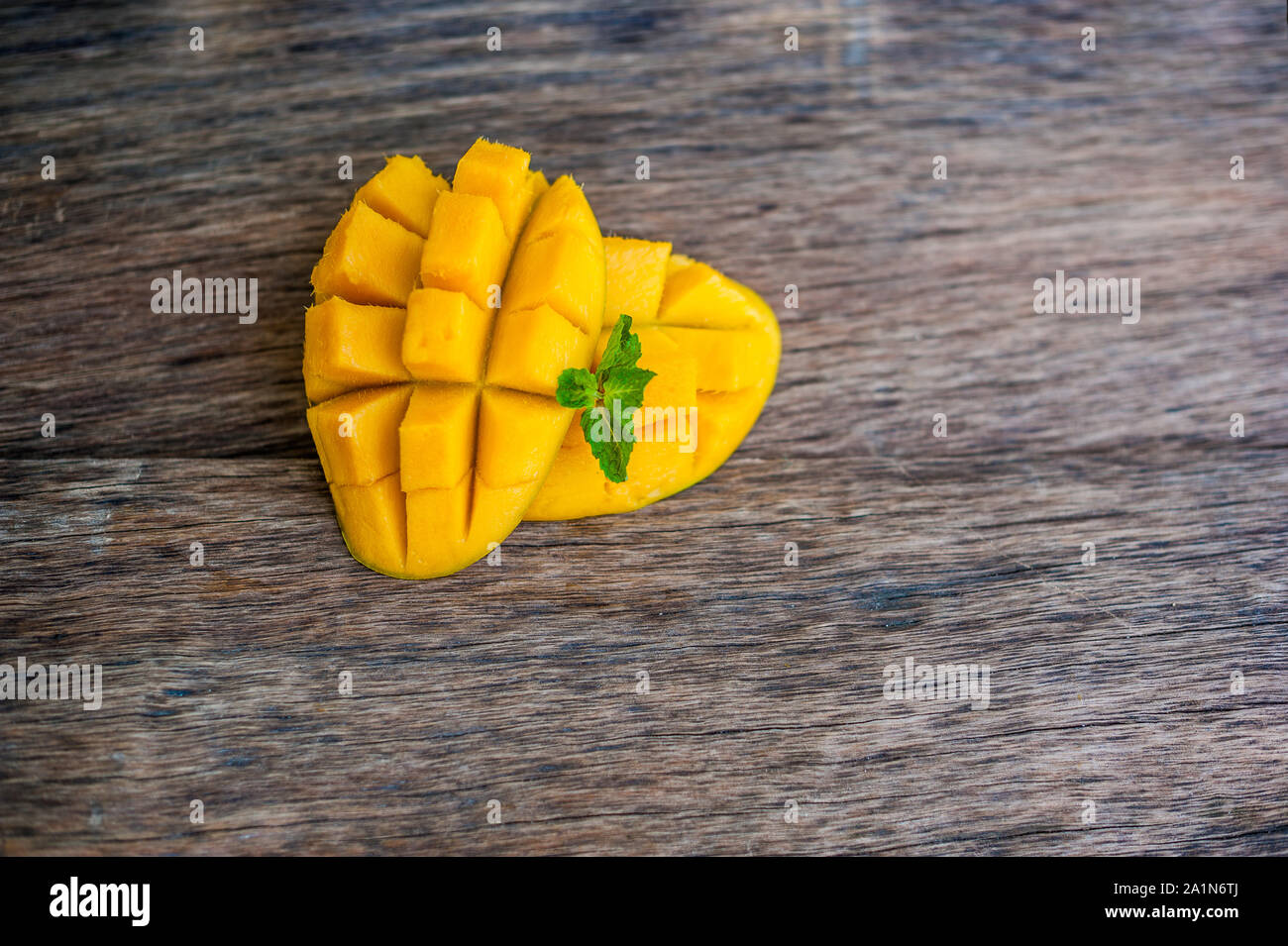 Mango-Frucht und Mango Würfel auf dem Holztisch. Stockfoto