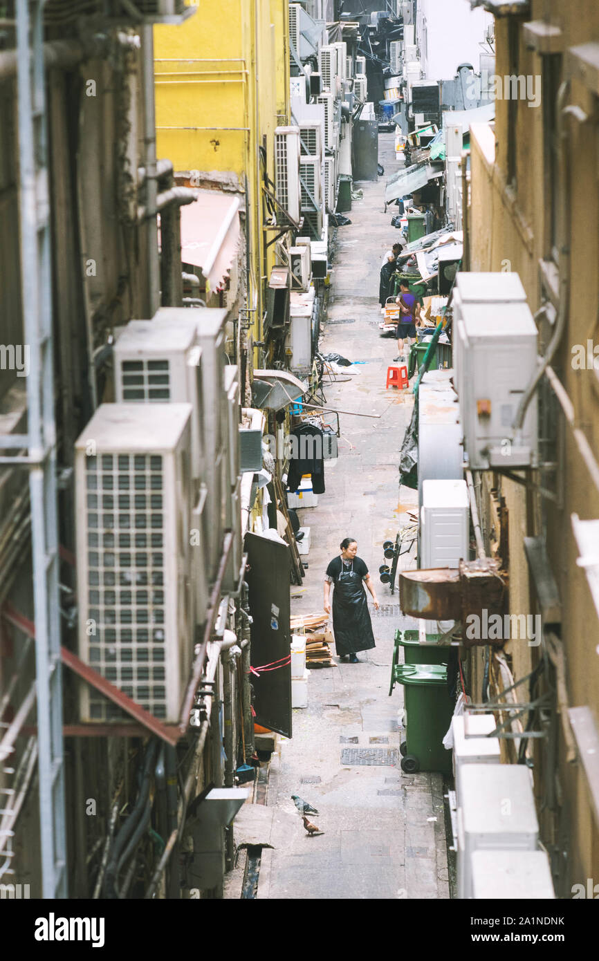 Gasse in Hongkong unter hohen Gebäuden. Stockfoto