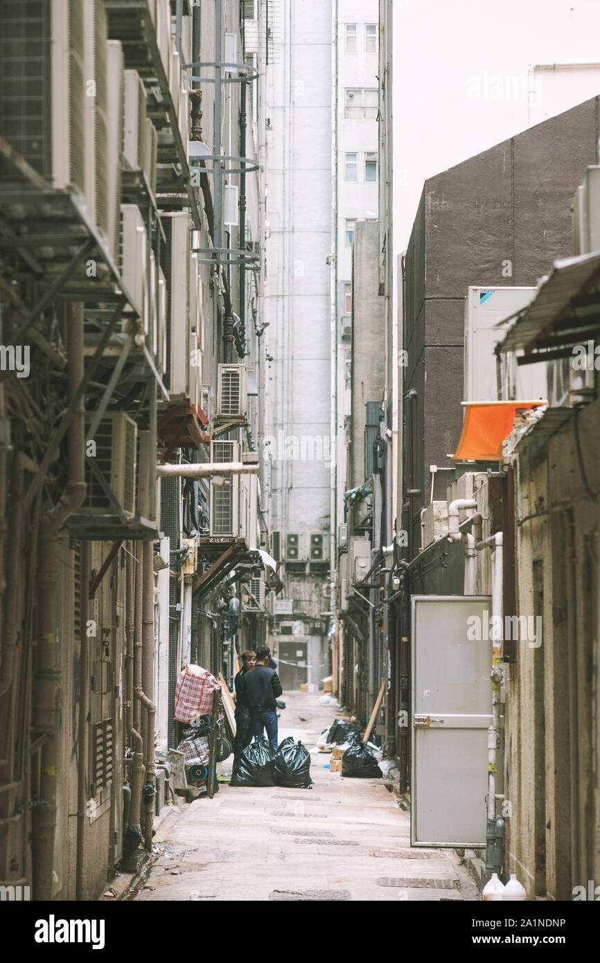 Gasse in Hongkong unter hohen Gebäuden. Stockfoto