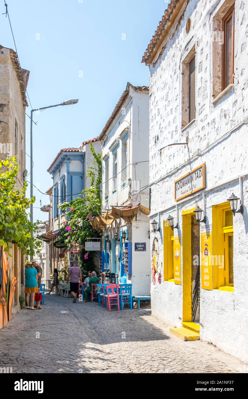 Alacati, Türkei - 4. September 2019: Menschen zu Fuß auf einer gepflasterten Straße. Die Stadt ist bei Touristen beliebt im Sommer Stockfoto