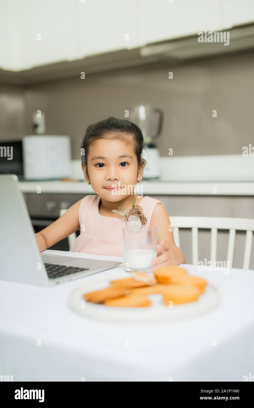 Gerne asiatische Familie essen Frühstück und siehe Digitale Tablet in der Küche zu Hause. Gesundes Essen und Morgen Aktivitäten Stockfoto