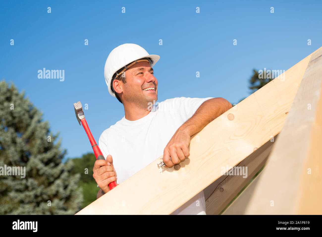 Freundliche Handwerker arbeiten hart daran, das Dach ein neues Haus zu bauen. Stockfoto