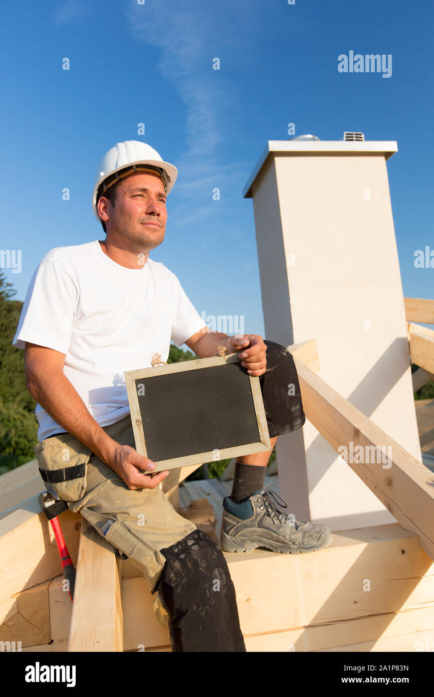 Junge Arbeitnehmer hält ein Schild in der Hand. Stockfoto