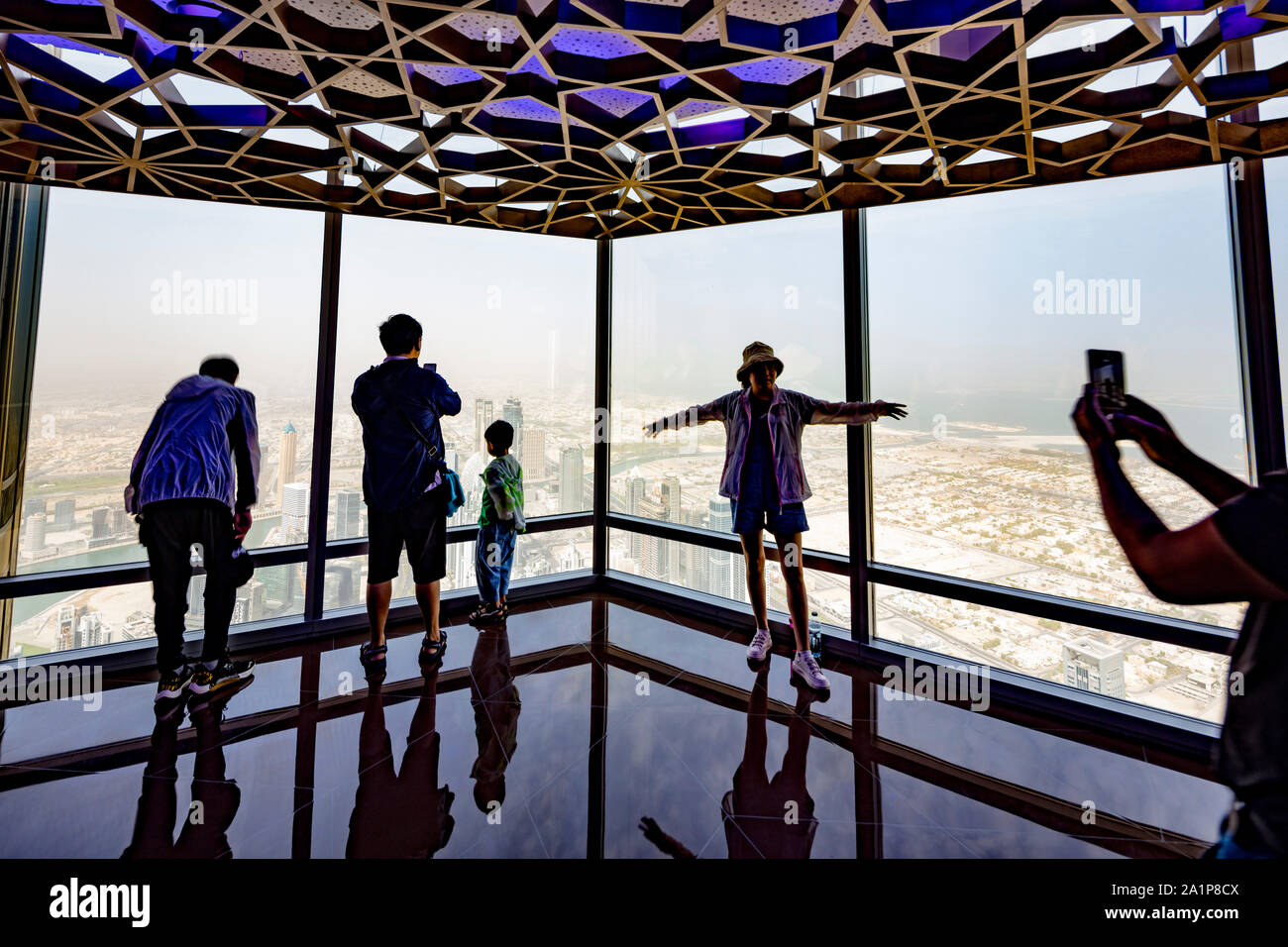 Chinesische Touristen fotografieren innerhalb der Aussichtsplattform des Burj al-Khalifa, Dubai, Vereinigte Arabische Emirate Stockfoto