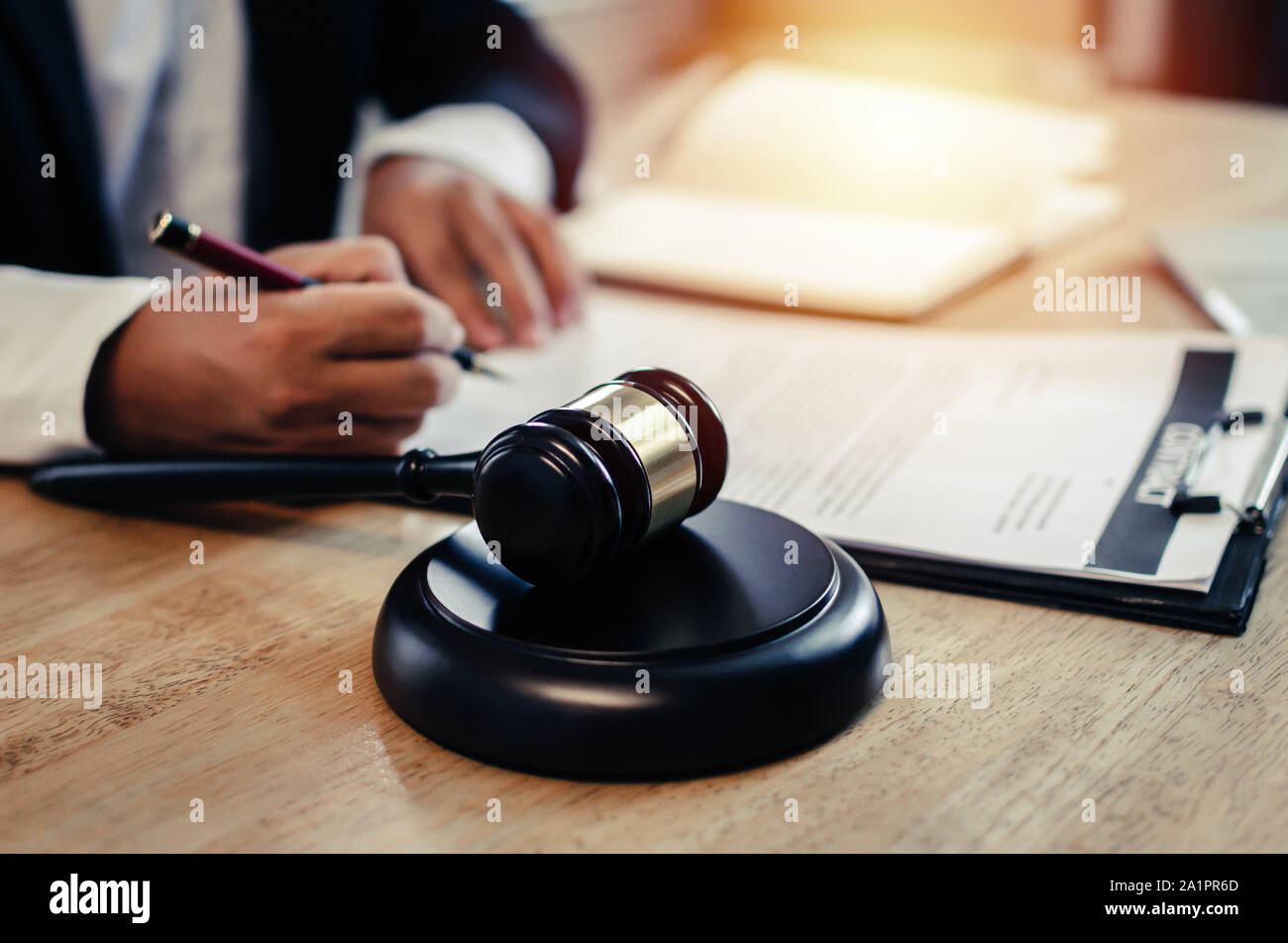 Justiz Rechtsanwalt in schwarzen Anzug über gesetzliche Vorschriften mit Dokumenten auf Arbeitsplatz und Holz Richter Hammer auf dem Schreibtisch im Gerichtssaal die Arbeit im Büro Stockfoto