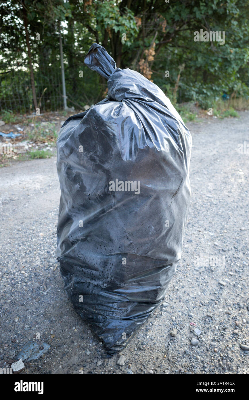 Illegal entsorgt schwarzen Müllsack im Querformat Stockfoto