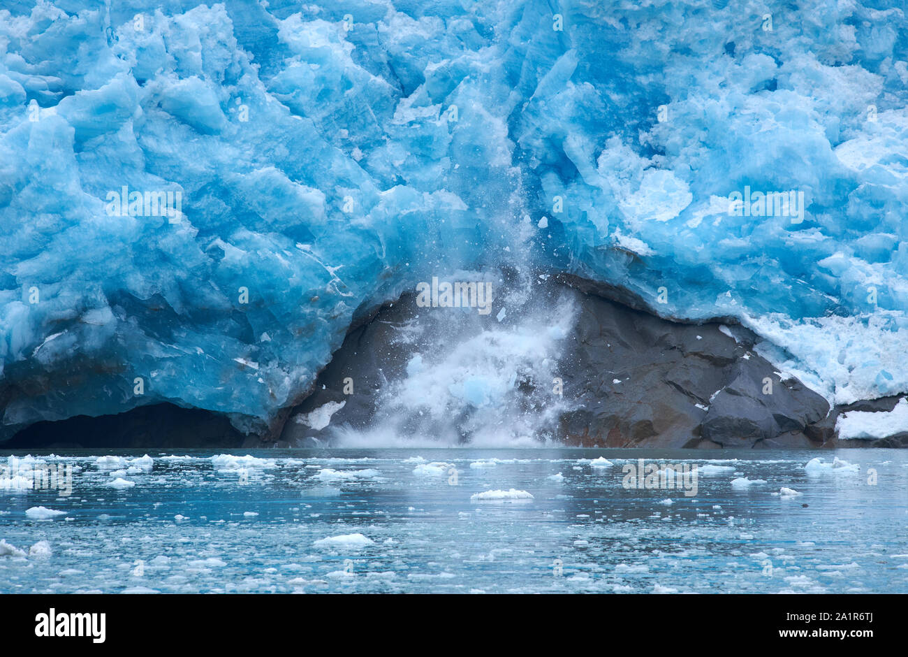 Ein Eisblock fällt ab und die vertikal geneigte Gletscherzunge des Northwestern Glacier und trifft auf einen Felsen (drittes von vier Fotos). Stockfoto