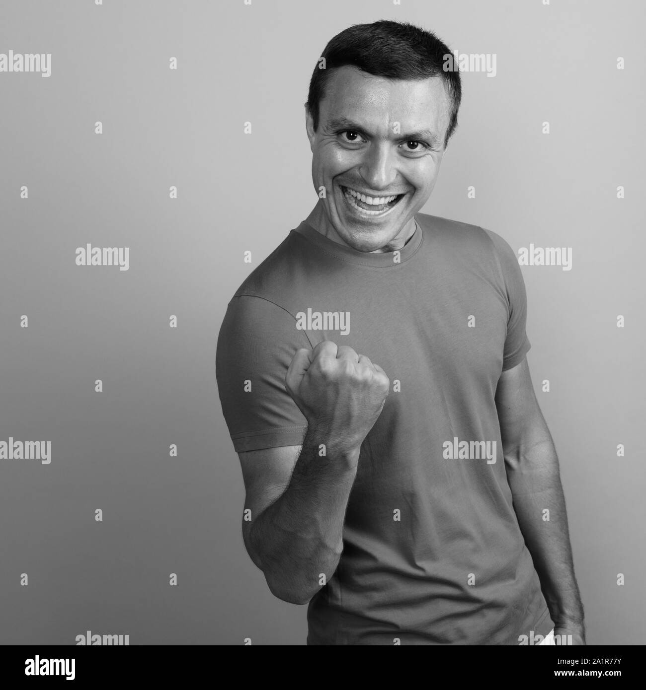 Mann-t-shirt gegen grauen Hintergrund shot in Schwarz und Weiß Stockfoto