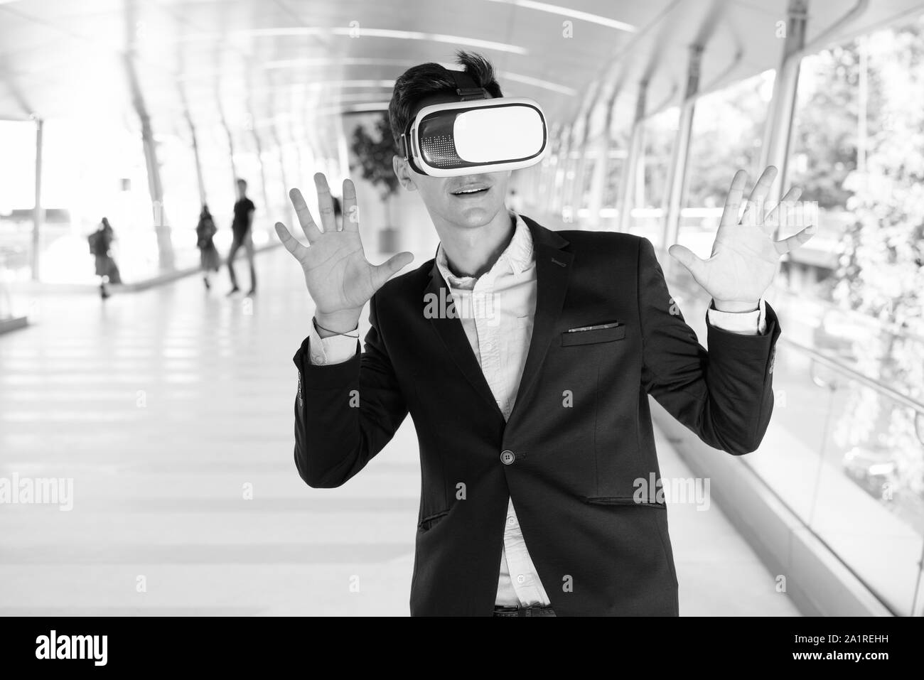 Junge gut aussehender Geschäftsmann mit VR-Brille im Freien Stockfoto