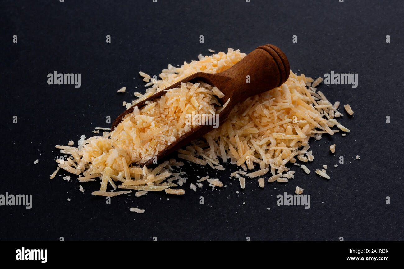 Geriebenen Parmesan auf schwarzem Hintergrund Stockfoto