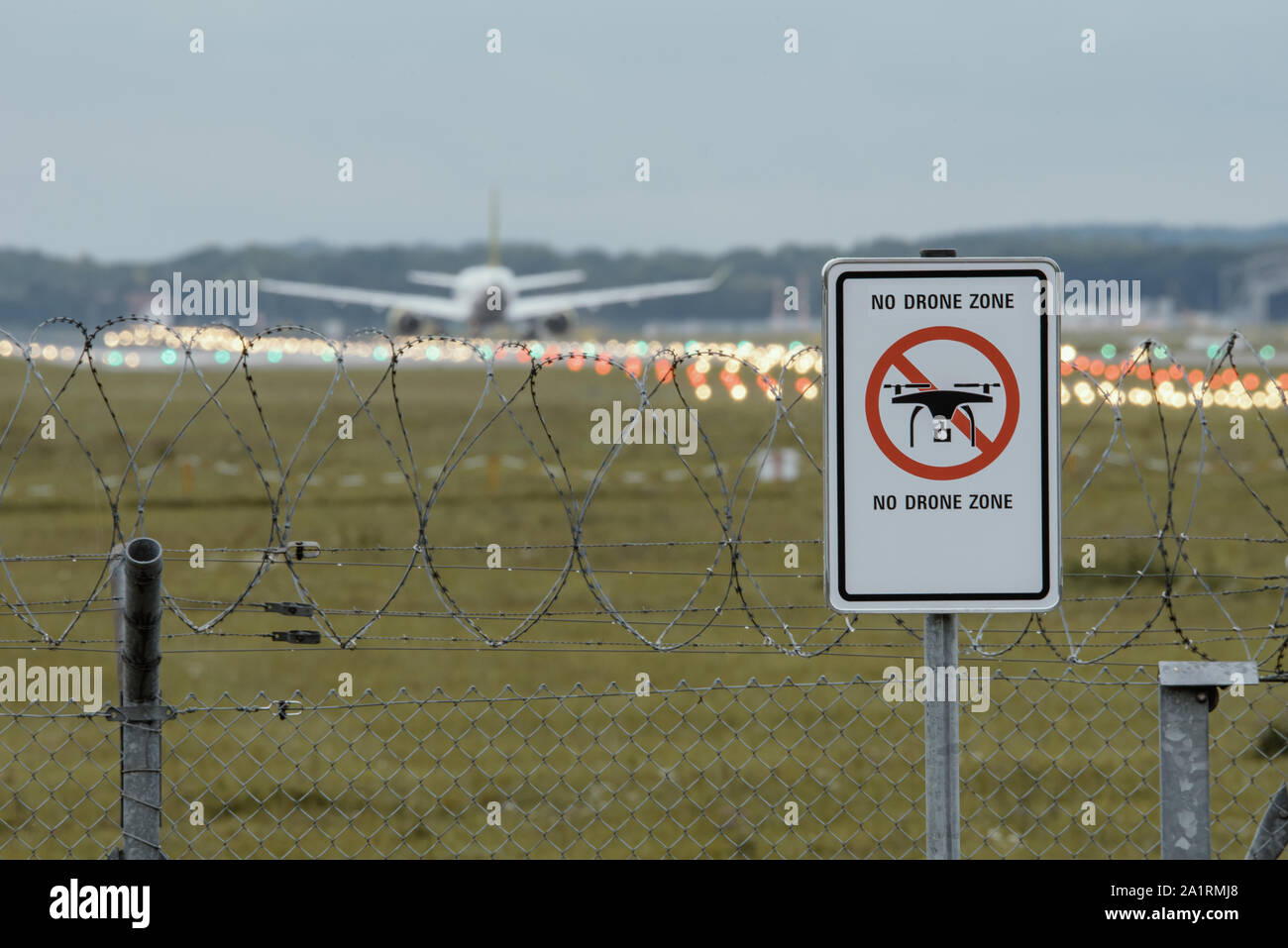 Schild am Flughafen" Kein Drone Zone" mit dem Flugzeug im Hintergrund Stockfoto
