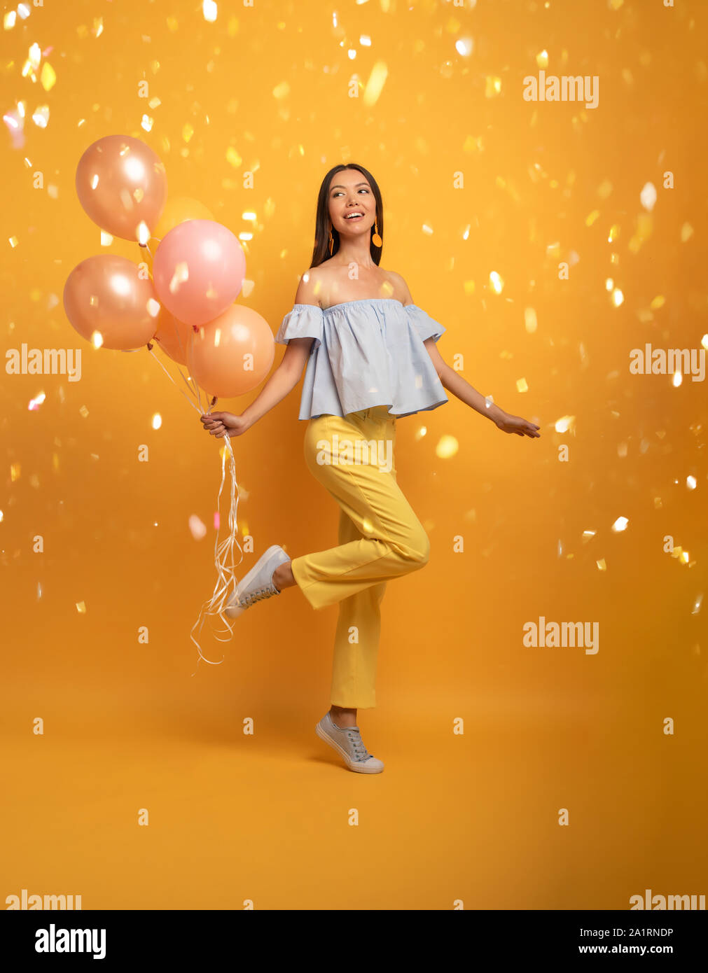 Mädchen bereit für eine Party mit Ballon. Freudige ein Glück Ausdruck. Gelber Hintergrund Stockfoto