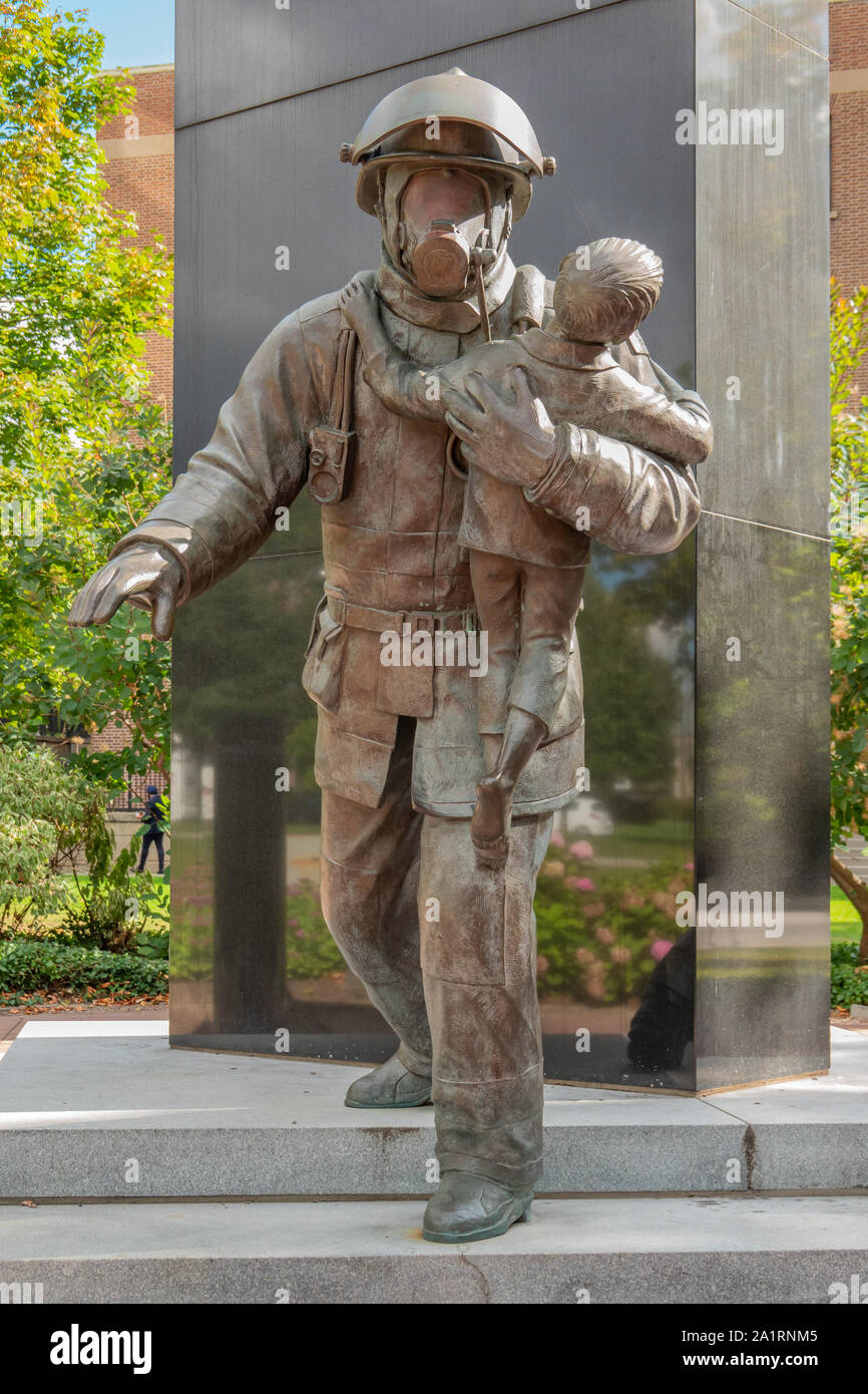 Bronzestatue von einem Feuerwehrmann mit einem kleinen Kind an der Ontario Firefighter Memorial in Toronto, Ontario, Kanada. Stockfoto