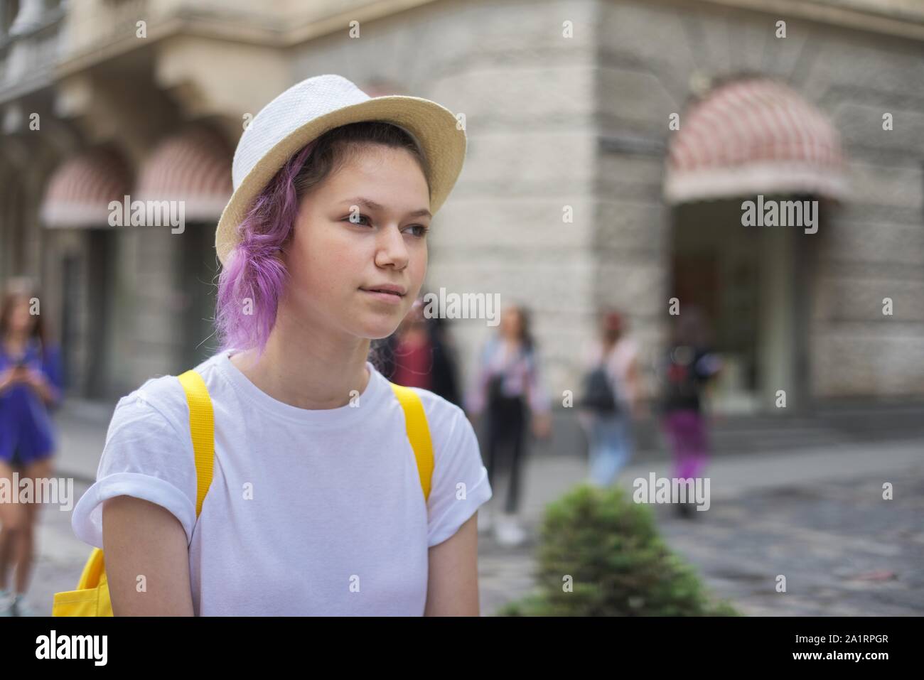 Outdoor Portrait von teenage Mädchen 15 Jahre alt in Hut mit trendigen Lila lila Haar, mit Rucksack Stockfoto