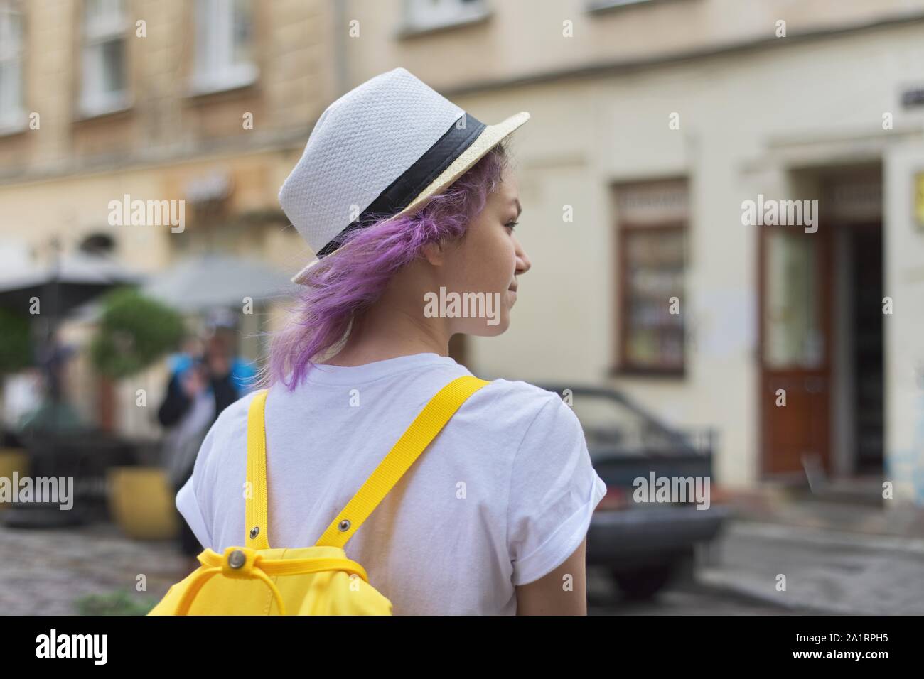 Outdoor Portrait von teenage Mädchen 15 Jahre alt in Hut mit trendigen Lila lila Haar, mit Rucksack Stockfoto
