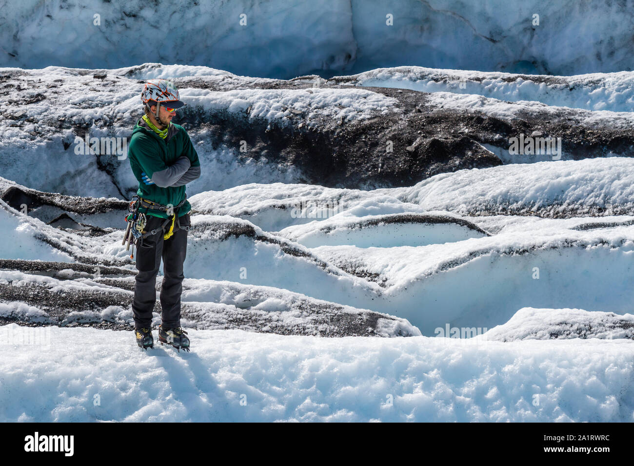 Ein Gletscher Guide steht Andere beobachten Auf der Matanuska Gletscher. Seine Arme sind gekreuzt, als er geduldig wartet. Stockfoto