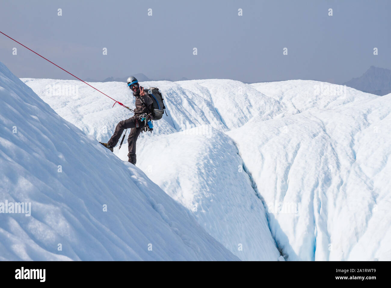 Ice climber, um eine Neigung von Eis mit einem roten Seil klettern auf der Matanuska Gletscher in Alaska abgesenkt. Stockfoto
