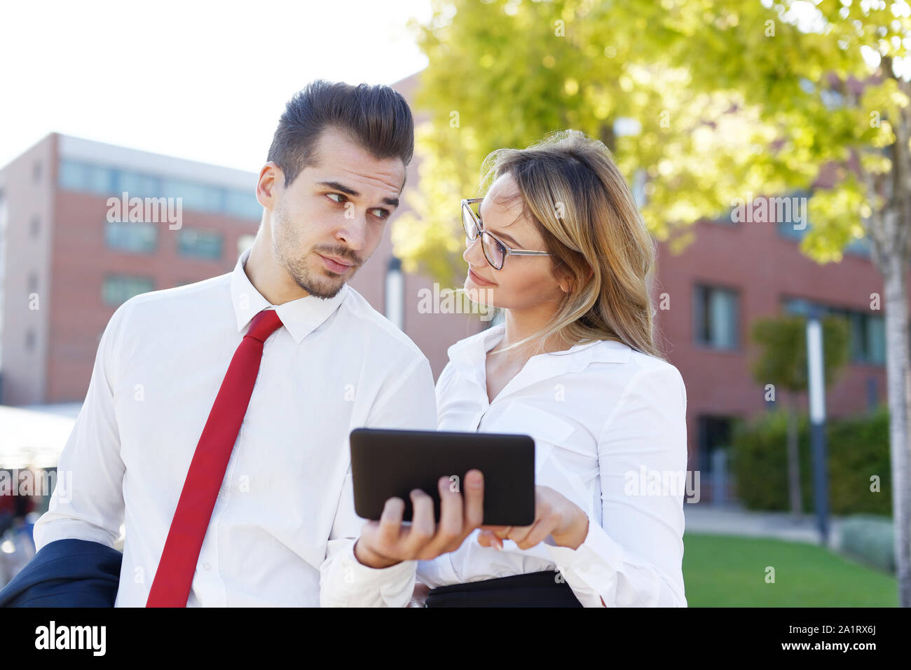 Junge Unternehmer mit der digitalen Tafel zu smiley Geschäftsfrau im Freien Stockfoto
