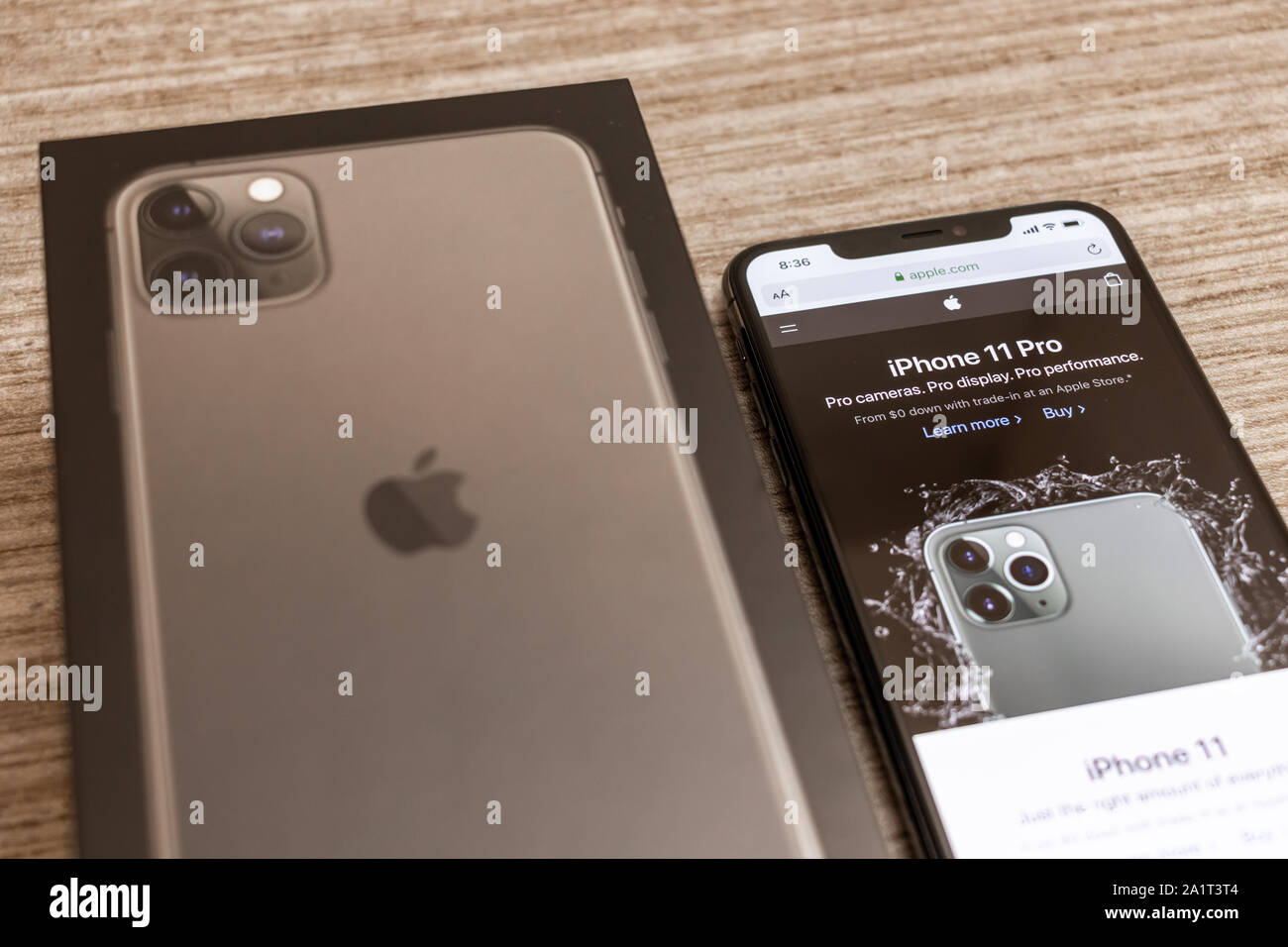 Neue iPhone 11 Pro und iPhone 11 Anzeigen auf der Apple-Website, auf dem iPhone neben iPhone 11 Pro-Box angezeigt. Stockfoto