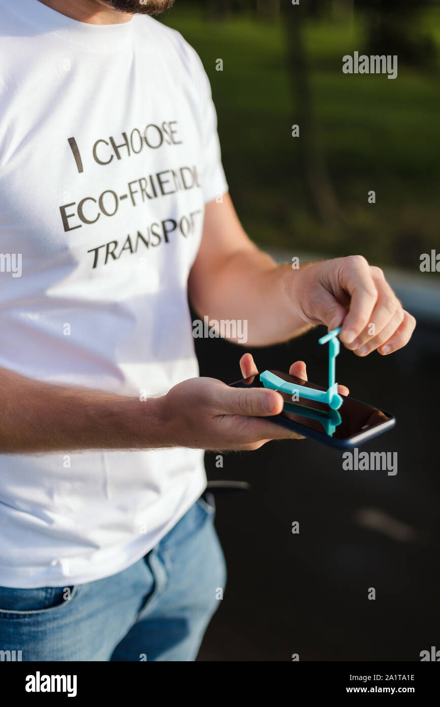 Ein Mann hält in seinen Händen eine Miniatur scooter Model auf einem Display, umweltfreundliche Stockfoto