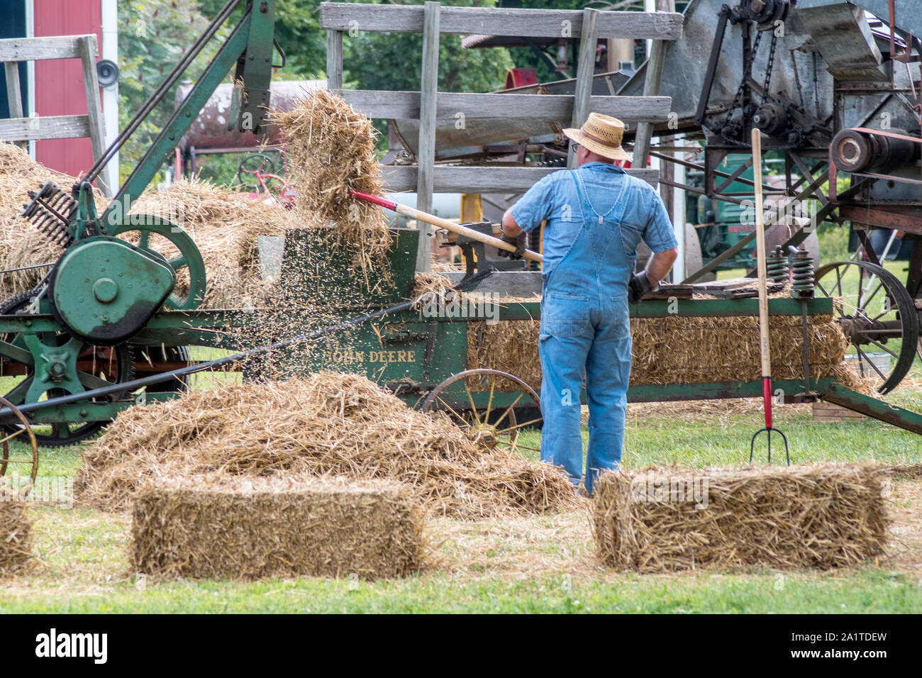 Hesston IN USA, 31. August 2019; ein Bauer Feeds eine Maschine mit frischem Heu, Heu am Hesston steam Show zu machen Stockfoto