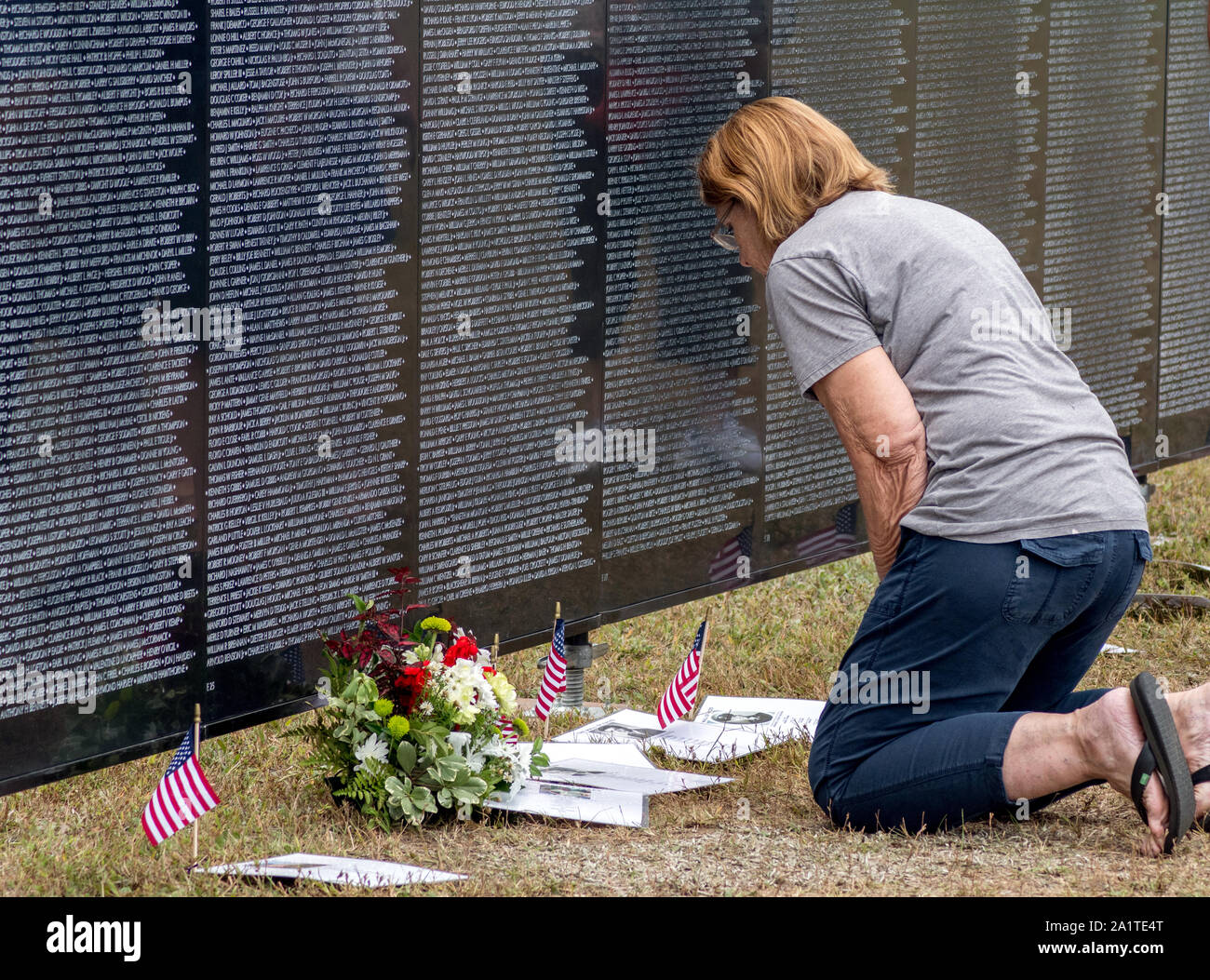 South Bend Indiana, USA, 21. September 2019; eine Frau kniet am Reisen Vietnam Memorial Wall, die Namen, die auf der Wand zu lesen, und die Fotos o anzeigen Stockfoto