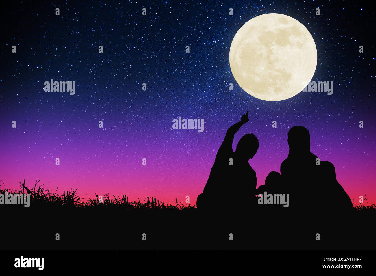 Glückliche Familie sitzt auf einem Hügel und beobachtete den Mond und Stern. Feiern in den Herbst Festival Stockfoto