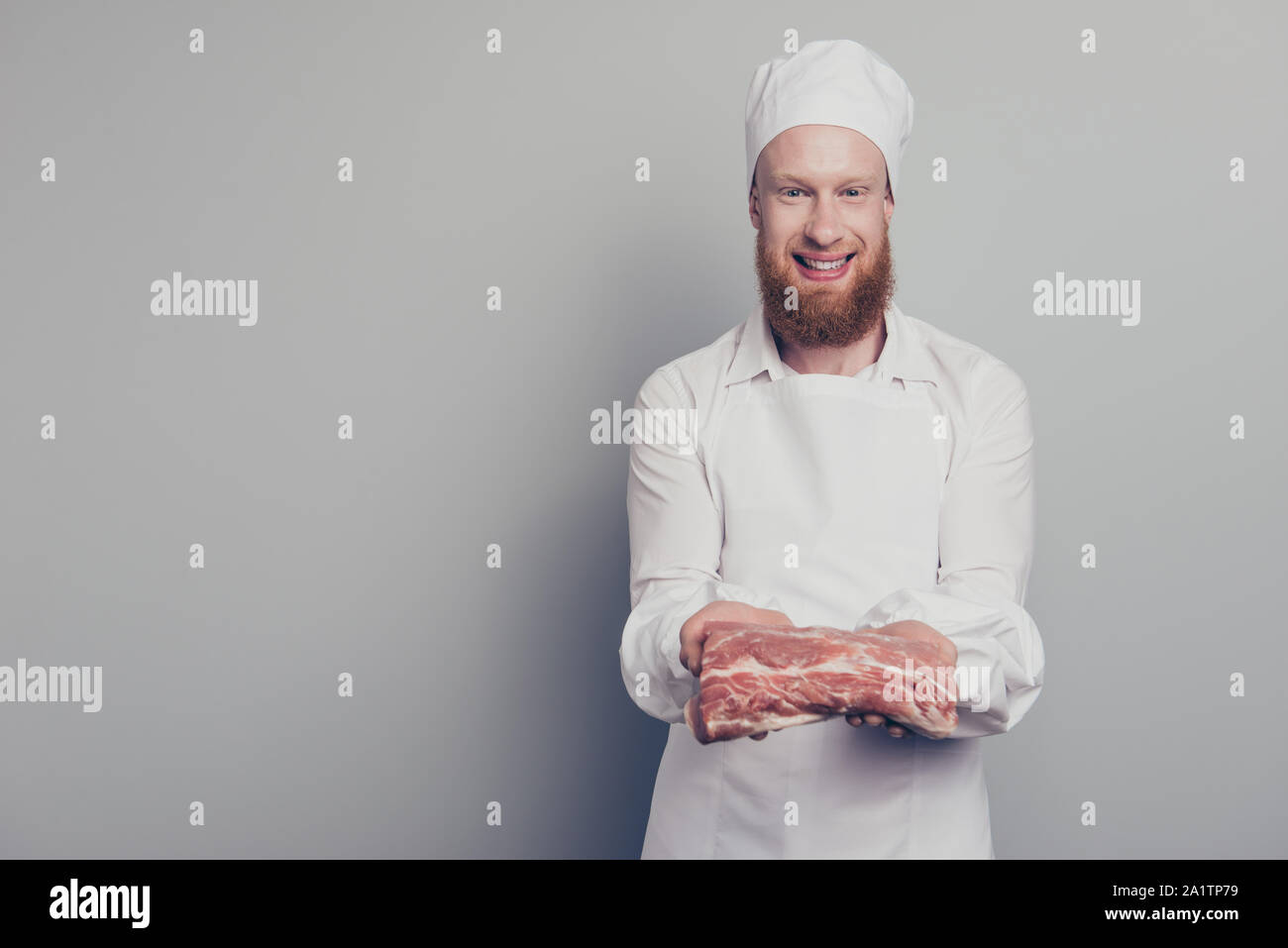Portrait von er schön schön schön schön fröhlich optimistisch Metzger guy Holding zeigt große Fleisch Stück in den Armen Hände bereit Gericht vorbereiten Stockfoto