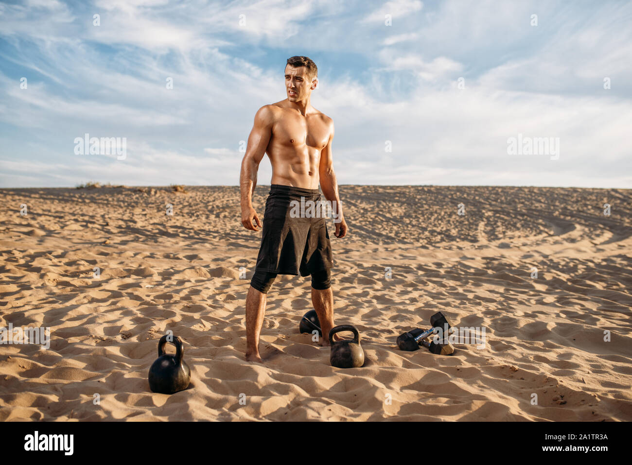 Athlet, Training mit Hanteln in der Wüste Stockfoto