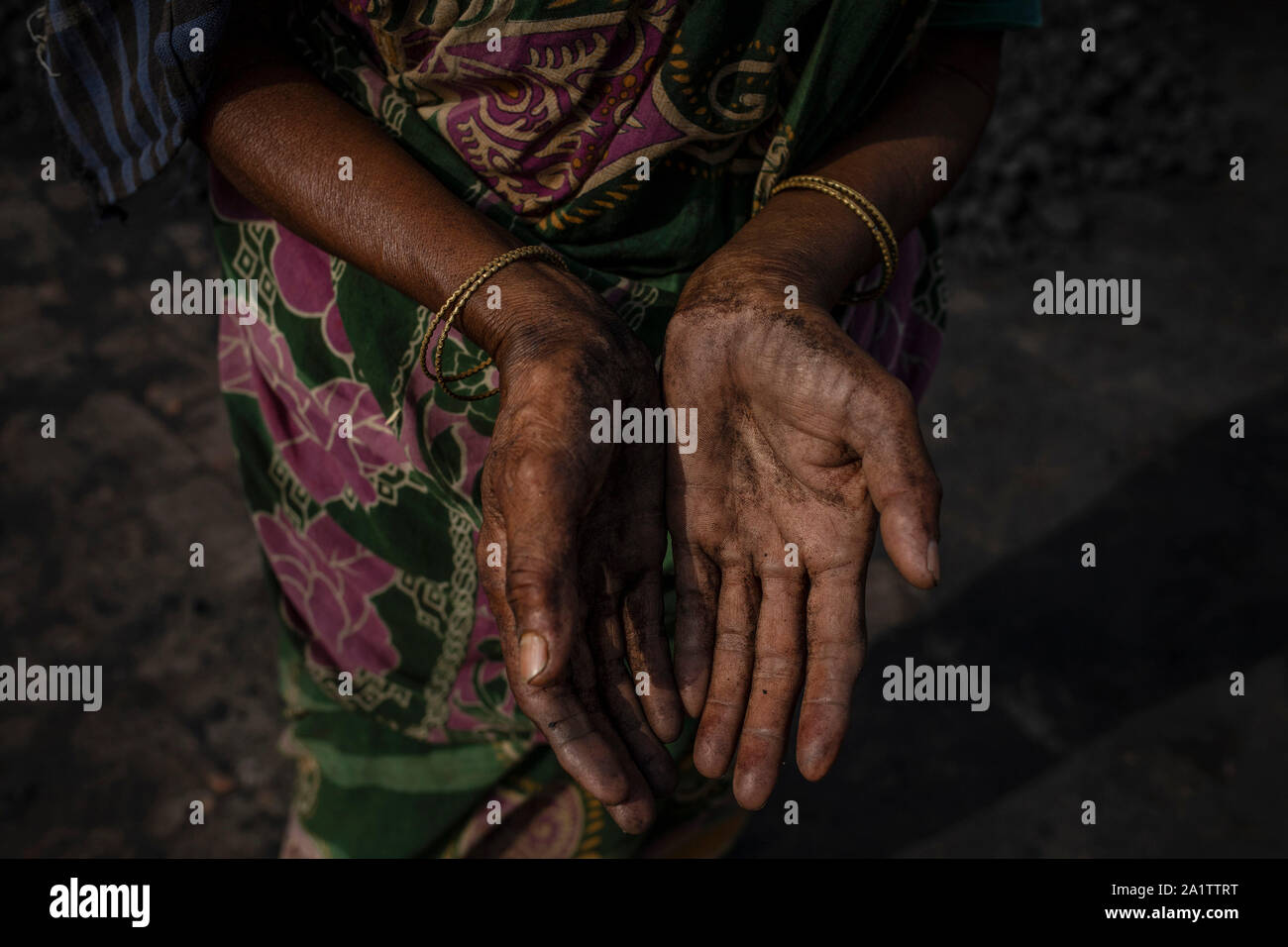 Folesa Begum, 57, zeigt ihre Hände, wie sie sortiert Kohle in einer Ziegelfabrik in der Nähe von Dhaka, Bangladesch, 30. April 2019 zu brennen. Stockfoto