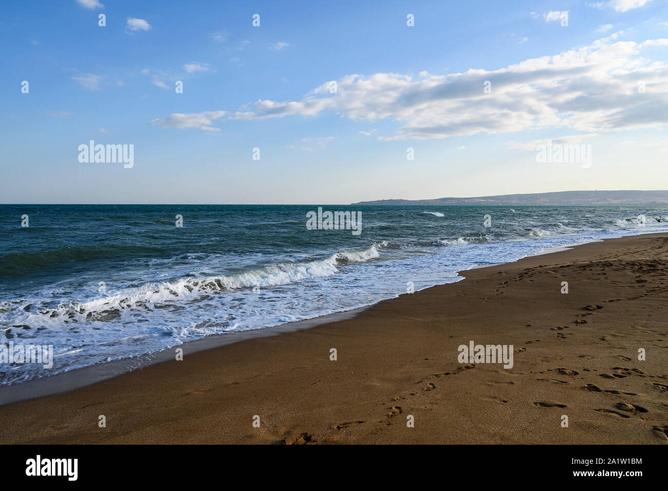Schwarzes Meer sonnigen Herbsttag. Sandstrand, kleine Welle und leichte Wolken im Himmel Stockfoto