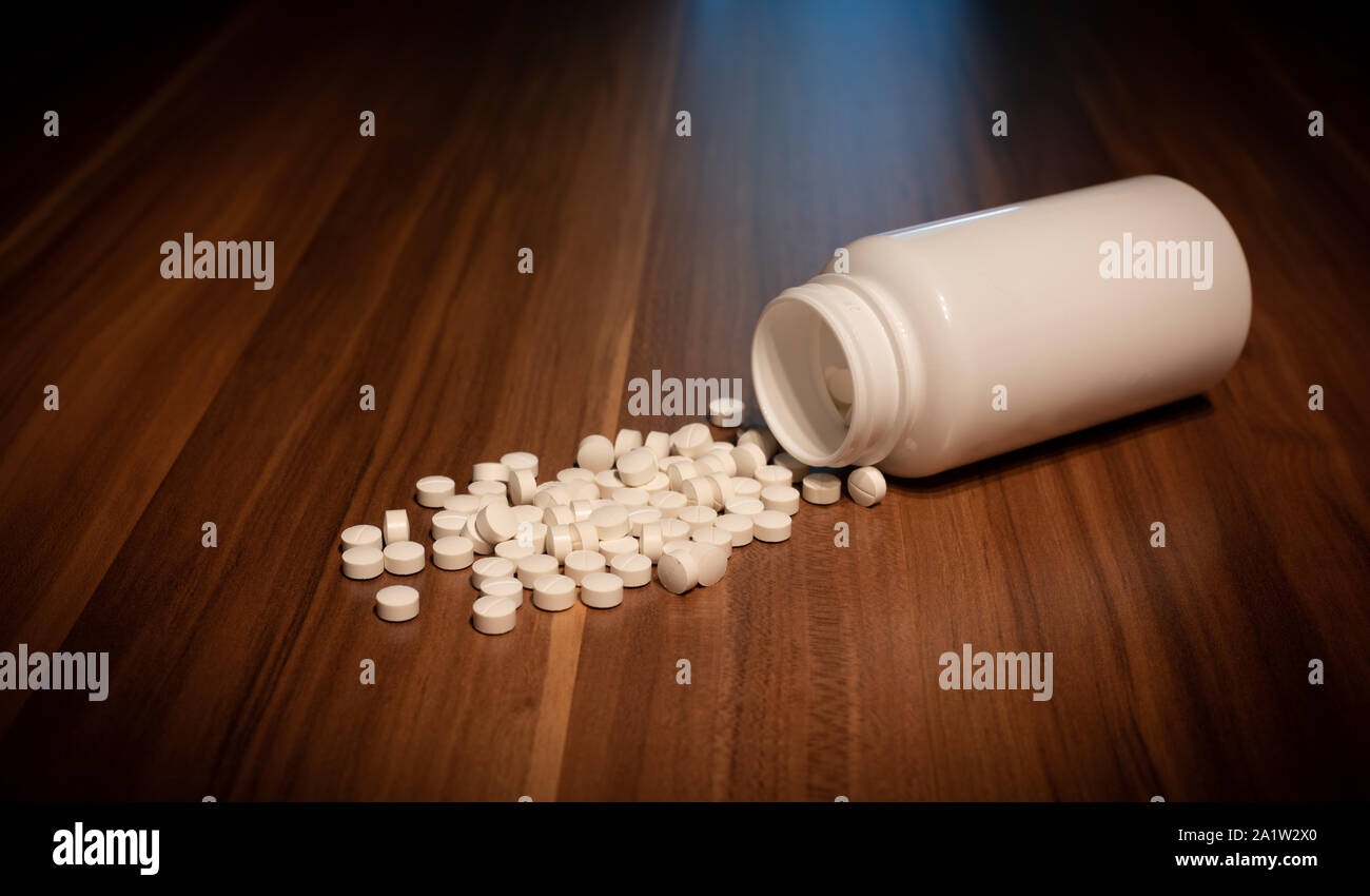 Weiße Kapseln Pille verschüttete Aus weißem Kunststoff Flasche container. Global Healthcare Konzept. Antibiotika Resistenzen. Stockfoto