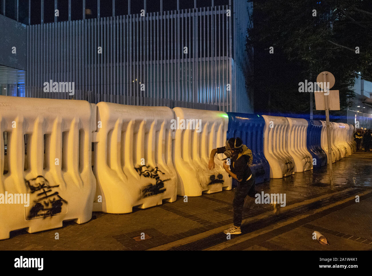 Eine Demonstrantin wirft einen Stein während der Rallye. regierungsfeindlichen Demonstranten das 5-jährige Jubiläum der Bewegung am Tamar Park in Hongkong zu gedenken. Stockfoto