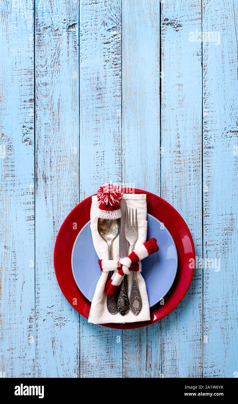 Weihnachten Tischdekoration mit festlichen Dekorationen in Form einer Strickmütze und Schal in Weiß und Rot auf einem alten hölzernen Hintergrund mit kopieren. Stockfoto