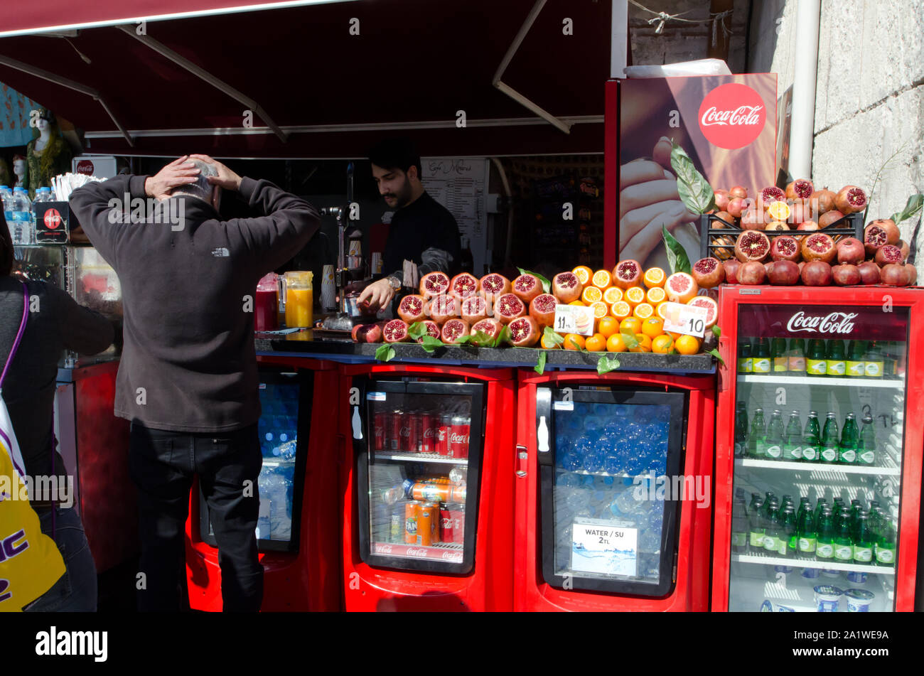 Istanbul, Türkei, März 08,2019: Kunde mit den Händen auf seinen Kopf im vorderen Ladenbereich mit frischen Früchten und Kühlschränke mit Saft und Wasser an einem sonnigen Tag Stockfoto