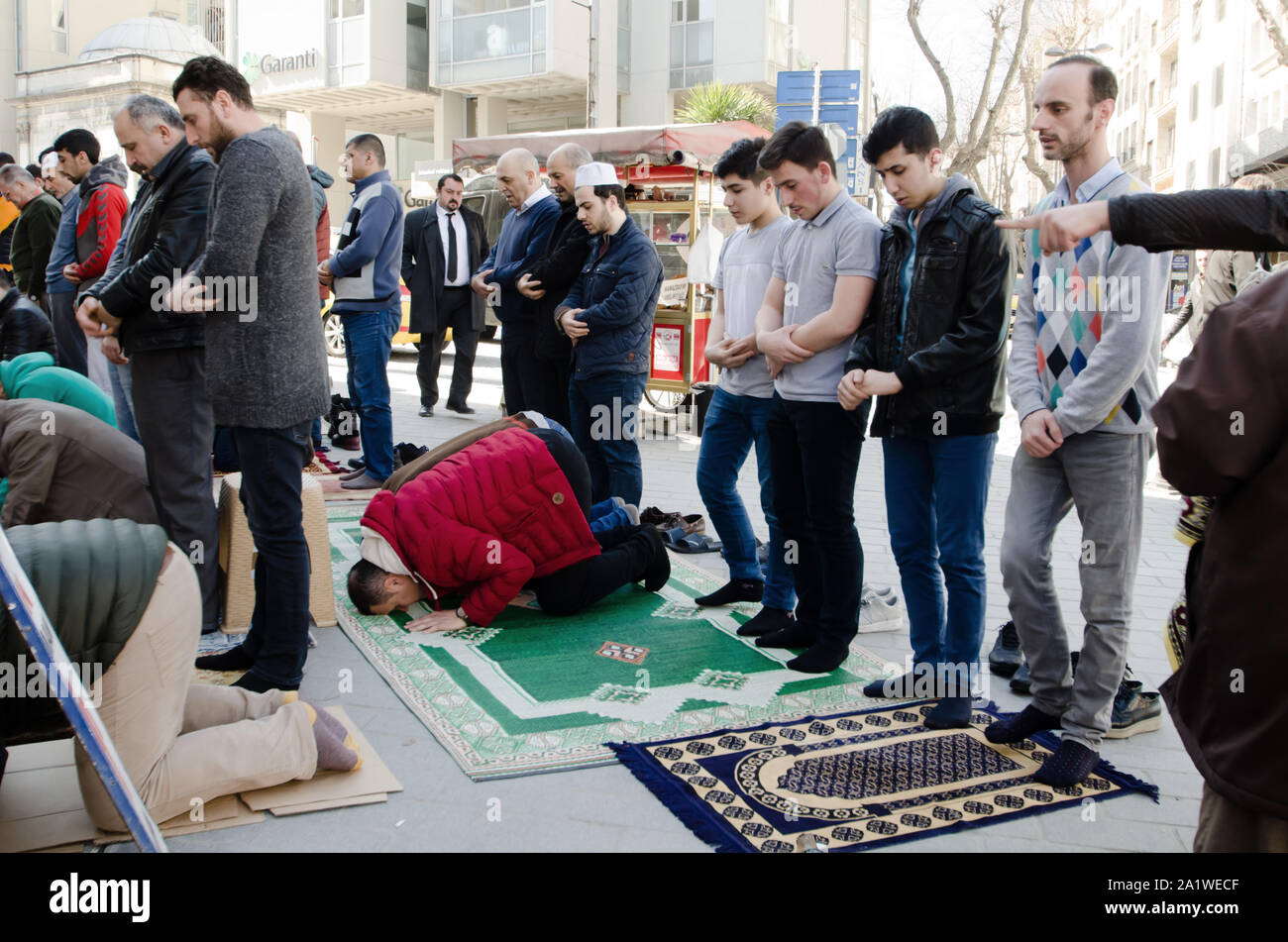Istanbul, Türkei, März 08,2019: Muslimische Männer beten auf der Straße vor vielen Moscheen in Istanbul an einem sonnigen Tag Stockfoto