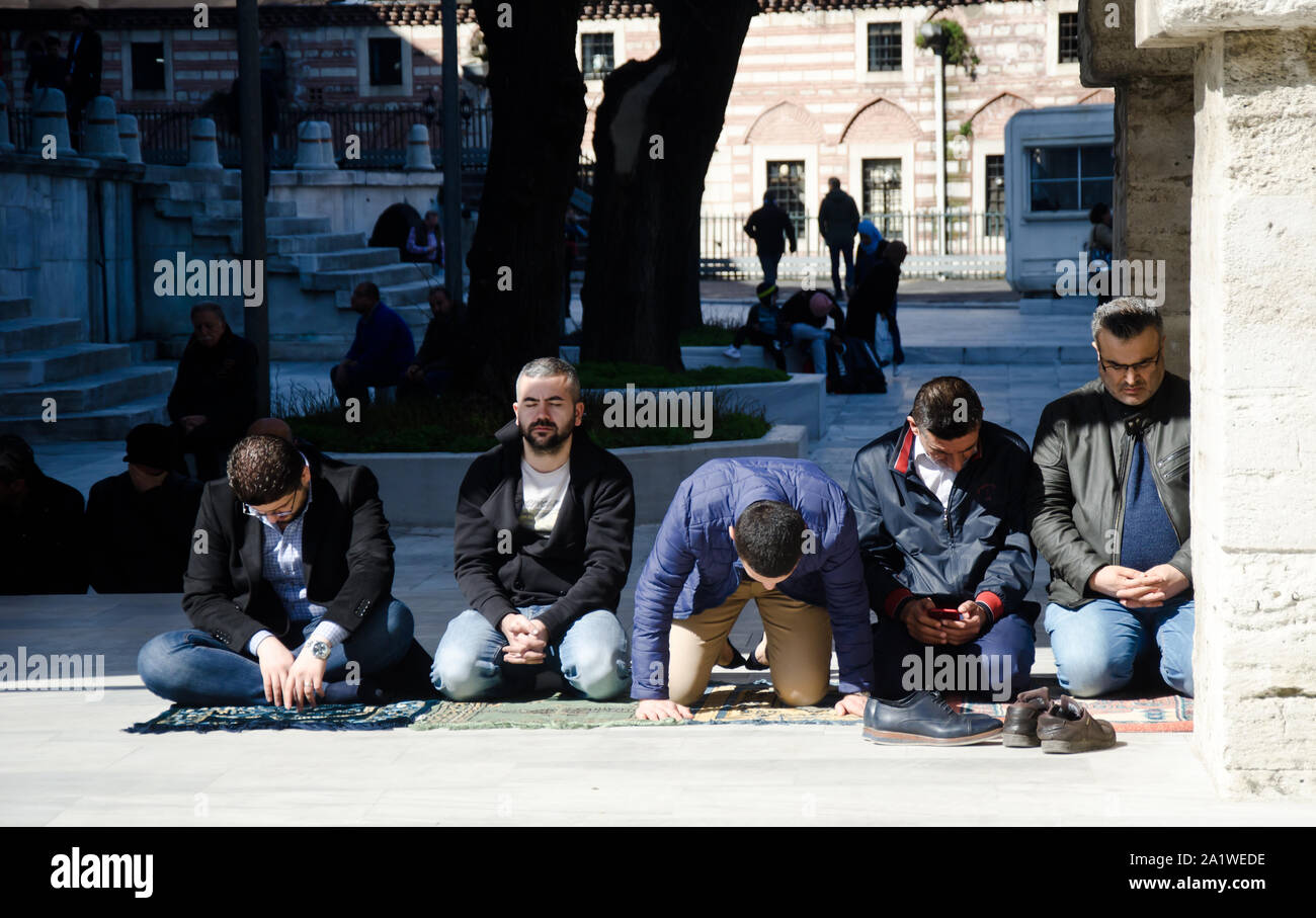 Istanbul, Türkei, März 08,2019: Fünf muslimische Männer beten auf der Straße vor der Nuruosmaniye Camii. Nuruosmaniye Moschee in Istanbul Stockfoto