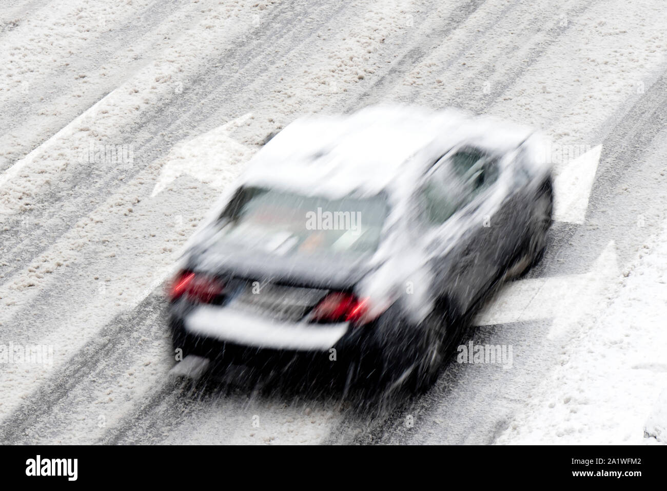Blurry Auto auf der leeren Straße der Stadt mit Richtungspfeil Straße Markierungen, die Sie beim einem Schneefall Stockfoto