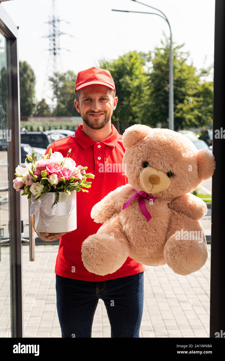 Positive Lieferung Mann mit Teddybär und Blumen Stockfoto