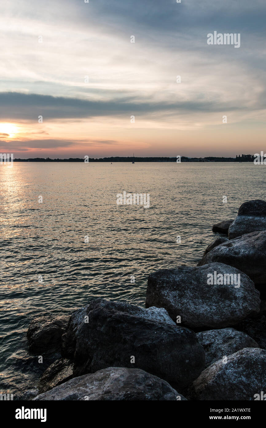 Kleine schwarze Landzunge in das Wasser und einen goldenen Sonnenuntergang Stockfoto