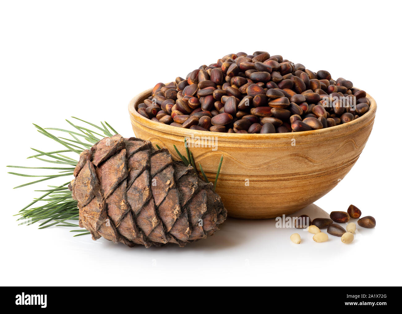 Ungeschälte zeder Muttern in die Schüssel und Zweig mit Pine Cone auf weißem Hintergrund Stockfoto
