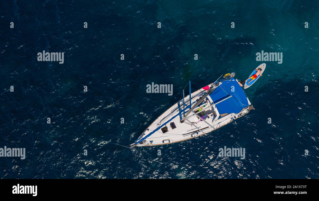 Luftbild einer Segelyacht vor Anker in einer geschützten griechischen Küste im klaren blauen Sommer Mittelmeer Stockfoto