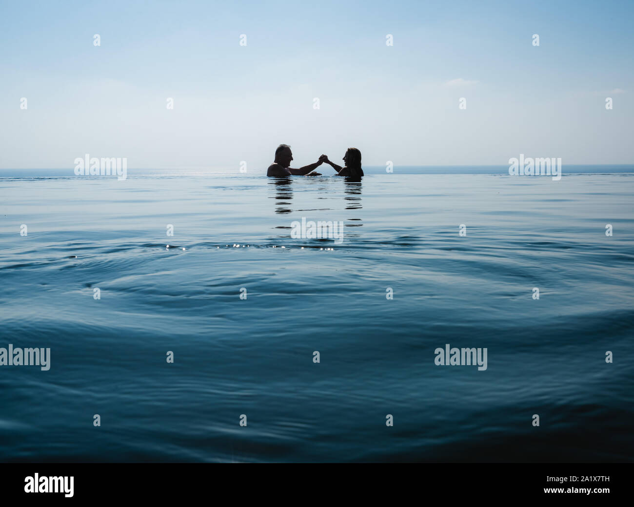 Paar ist Schwimmen im Pool gegen schöne blaue Meer Stockfoto Paar ist Schwimmen im Pool gegen schöne blaue Meer Stockfoto