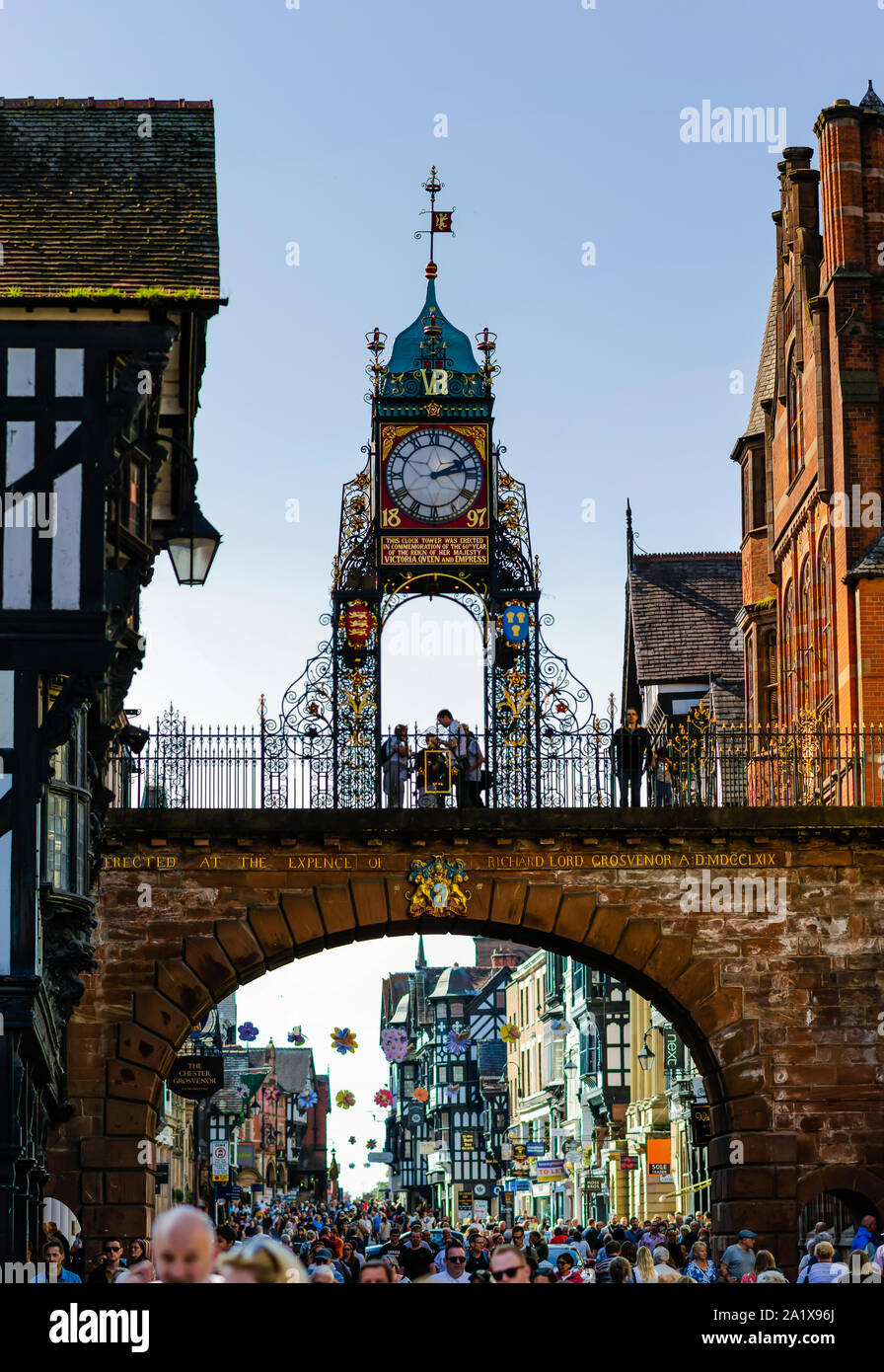 Iconic Chester Eastgate Clock und das Eastgate Street voll mit Menschen. Diese hohe Auflösung vertikale Panorama Foto ist von 4 Schüsse. Stockfoto