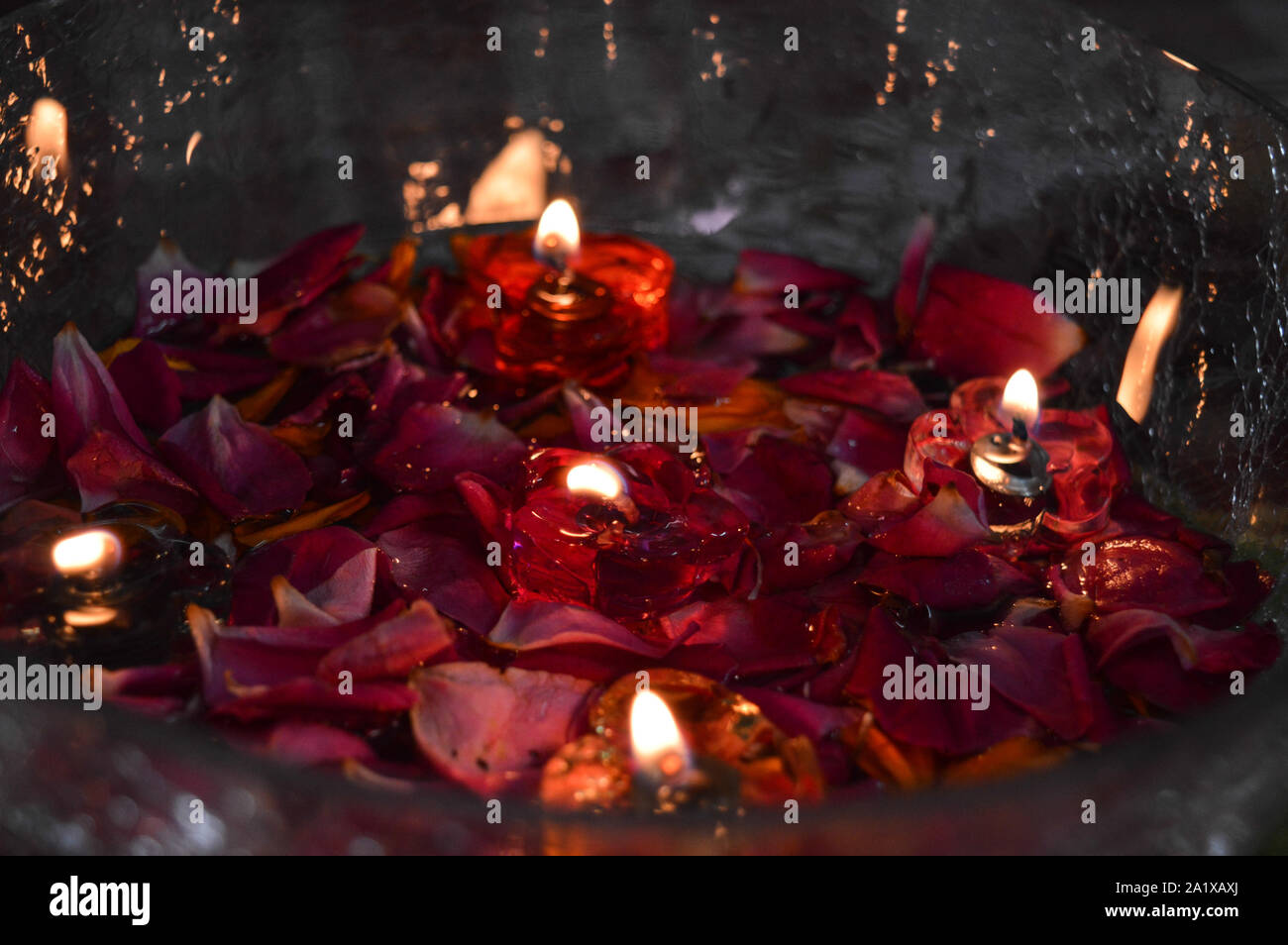 Ein Glas, das sich mit Rose geladen und Kerze auf indischen Festival diwali deepawali mit Feuer am Tisch isoliert Stockfoto