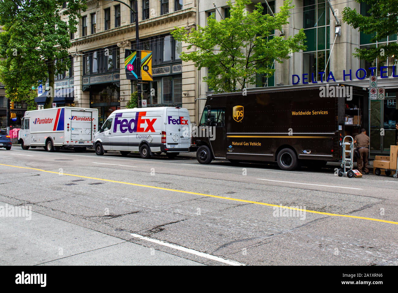 Purolator, FedEx und UPS LKW auf der Straße geparkt Stockfoto