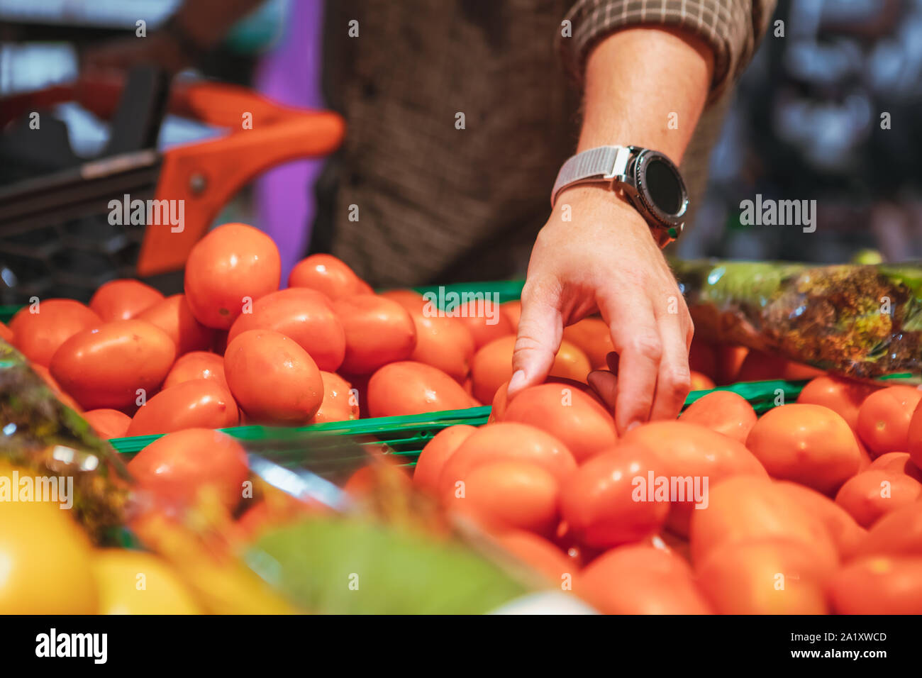 Hand Wahl rote Tomaten in Lebensmittelgeschäft Stockfoto