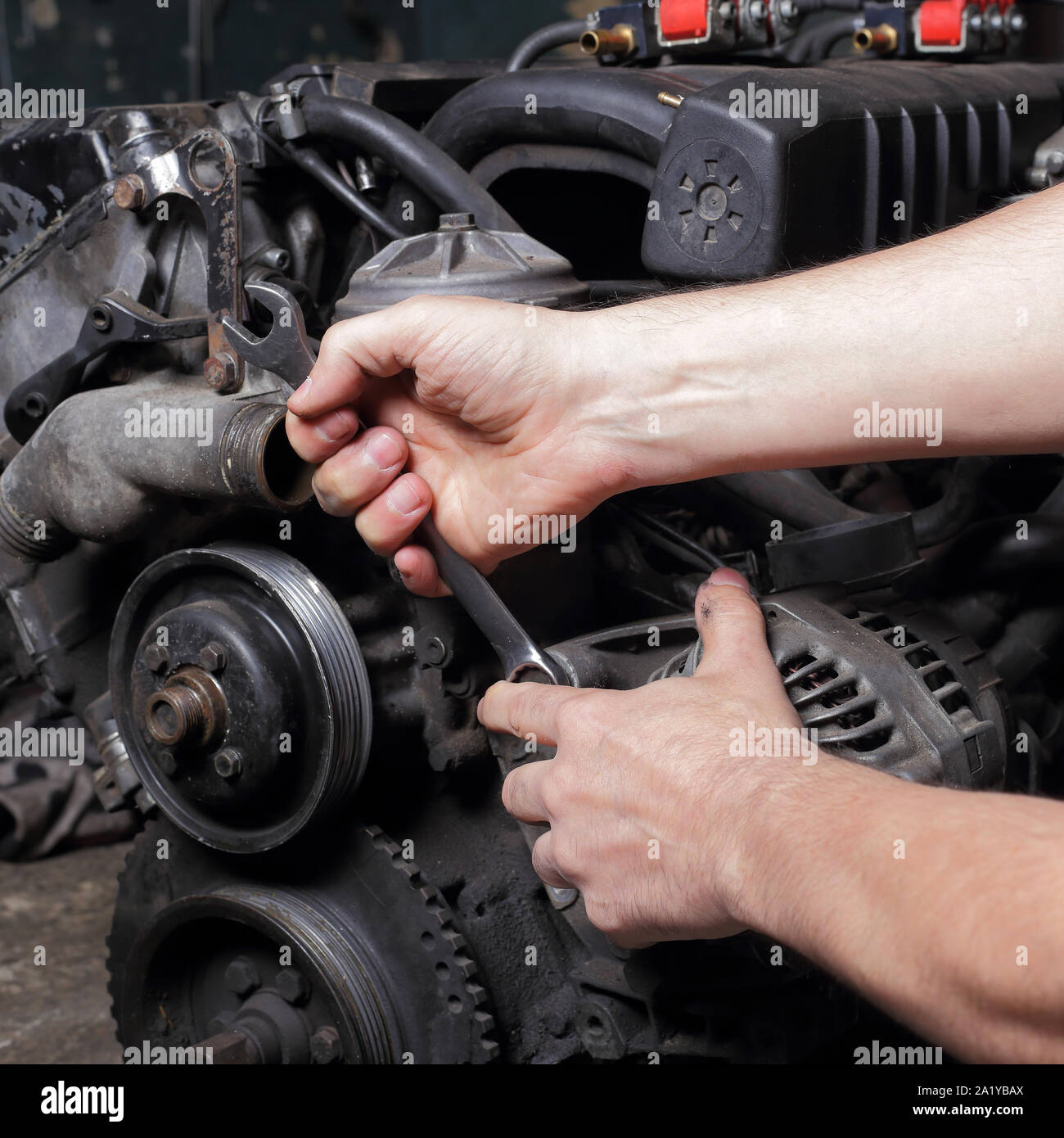 Auto Service - Reparatur des Motors, Mechaniker Hände mit Schlüssel deaktiviert generator Mutter Stockfoto