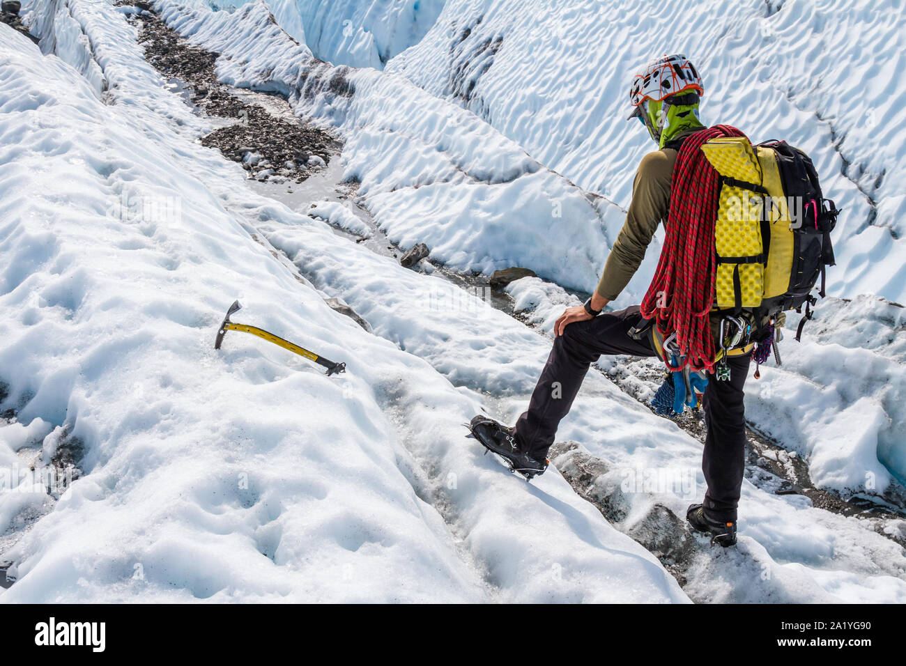 Trekking mit Klienten über den Matanuska Gletscher in der Chugach Mountains von Alaska, der Guide hält das Gelände voran zu bewerten und einen Weg finden. Stockfoto