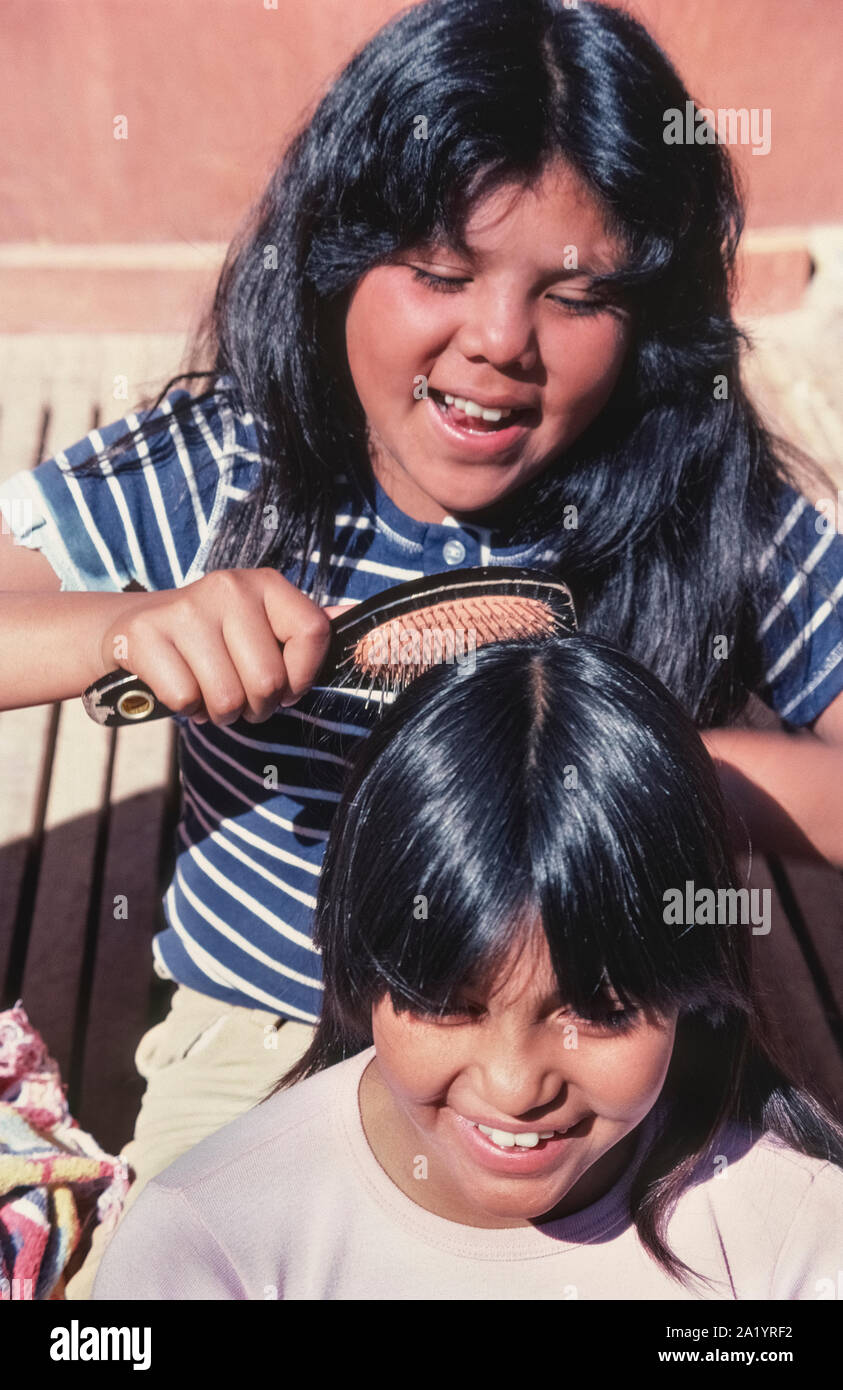 Zwei amerikanische indische Mädchen nehmen sich gegenseitig Putzen glänzendes schwarzes Haar in dem abgelegenen Dorf Supai, der Havasupai Stamm, als Volk des Blau-grün Wasser, die acht Meilen unterhalb des Rim des Grand Canyon in Arizona, USA, lebt. Wasser aus einem Kalkstein aquifer auf dem indischen Reservierung bewässert Feldfrüchte, die viele der 650 Stammesangehörige erlauben, tief in den berühmten Canyon zu leben. Eine große Attraktion gibt es schönen Havasu Falls, ein Ziel für mehr als 20.000 Abenteuerliche Wanderer jährlich. Dorf Supai ist nur zu Fuß, zu Pferd oder mit dem Hubschrauber erreichbar. Stockfoto
